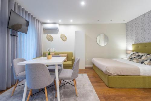 a hotel room with a bed and a table and chairs at Braga Center Apartments - Eça de Queirós in Braga