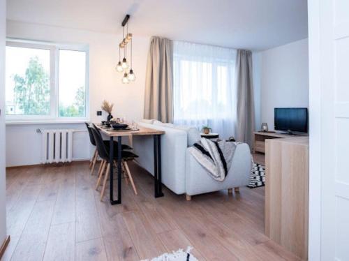 ein weißes Wohnzimmer mit einem Tisch und einem Stuhl in der Unterkunft Cozy little home, Mai 17 in Pärnu