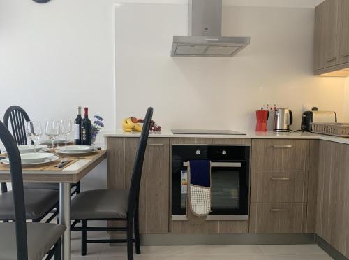 a kitchen with a table and a stove top oven at Quiet, Cosy Mellieha Apartment In Ghadira Bay in Mellieħa