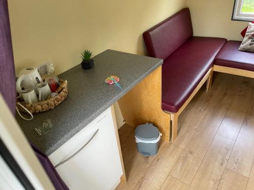 a kitchen with a counter with a bench and a table at Belle Vista Glamping & Camping in York