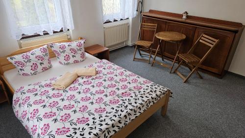 a bedroom with a bed and a table and chairs at U Pohody in Kovářská