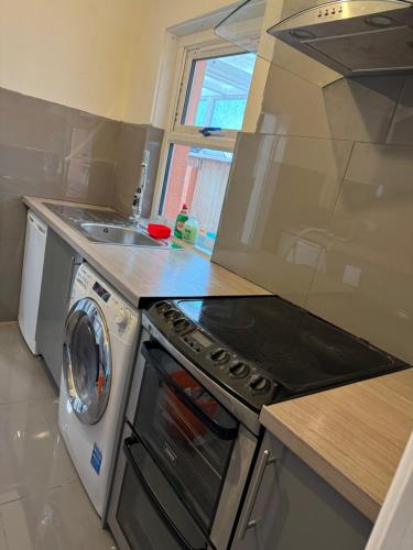 cocina con lavadora y fregadero en high street home en Eastleigh