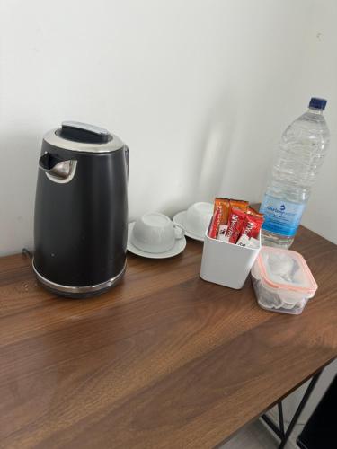 a coffee maker on a wooden table with a bottle of water at high street home in Eastleigh