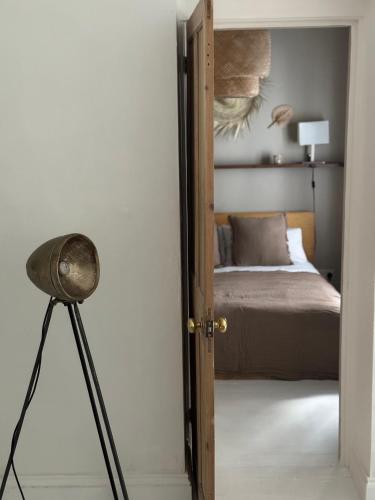 a door to a bedroom with a bed and a lamp at NEW Camden Kentish Town garden London up to 4 ppl in London