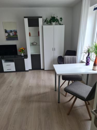 sala de estar con mesa blanca y sillas en Immergrün en Wustrow