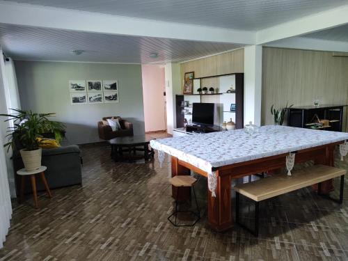 a living room with a table and a couch at Casa ampla com vista para as montanhas com piscina in Nova Friburgo