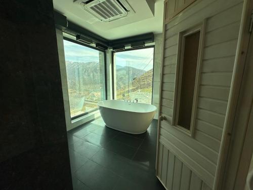 a bathroom with a tub in front of a window at Hovk Farms in Dilijan