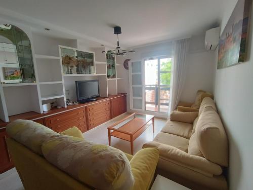 sala de estar con sofá y TV en Apartamento cerca de la playa, en Huelva