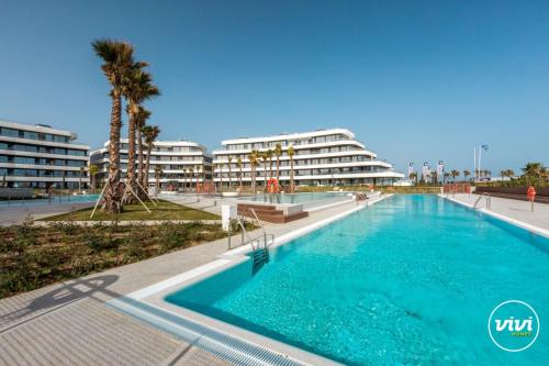 ein Schwimmbad vor einigen Wohnhäusern in der Unterkunft ViVi Homes - Galatea Pool, Gym, Sauna & Beach in Torremolinos