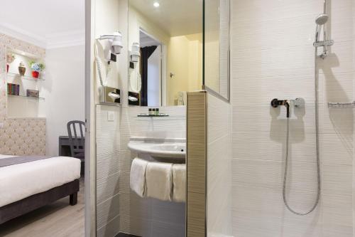 La salle de bains est pourvue d'un lavabo et d'une douche. dans l'établissement Résidence du Pré, à Paris