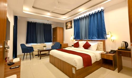 Hotel Down Town Paschim Vihar في نيودلهي: غرفة فندق بسرير والستائر زرقاء