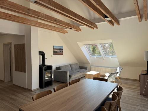 a living room with a table and a wood stove at Resort Vila Credo in Vysoke Tatry - Dolny Smokovec