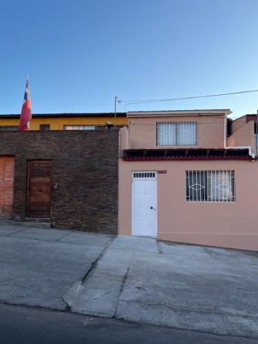 a pink building with a white door and a garage at Casa Central, Amplia y Cómoda in Antofagasta