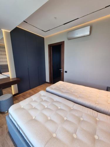 a large bed in a room with a ceiling at Premium apartment in Porta Batumi Tower in Batumi