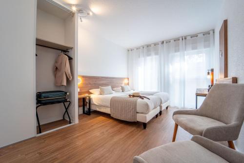 une chambre d'hôtel avec deux lits et une chaise dans l'établissement Hôtel Restaurant La Forestière, à Biscarrosse-Plage