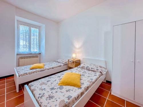 Un dormitorio con dos camas y una mesita de noche. en [5Terre]Nel Verde sul Mare - Relax in the Greenery, en Sestri Levante