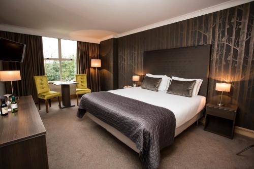 a hotel room with a large bed and a desk at Brandon House Hotel in New Ross