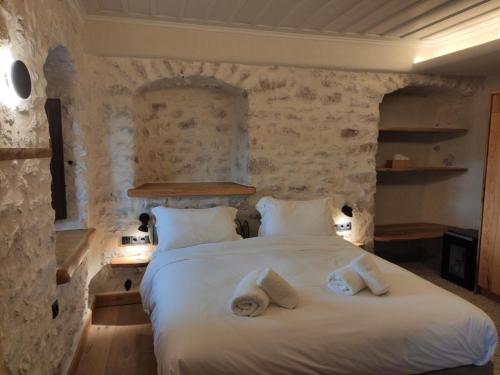 a bedroom with two beds in a stone wall at Casagli Luxury Suites in Dhimitsana