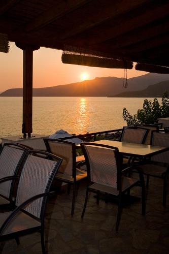 a group of tables and chairs in front of the water at Anniska Hotel in Kardamili