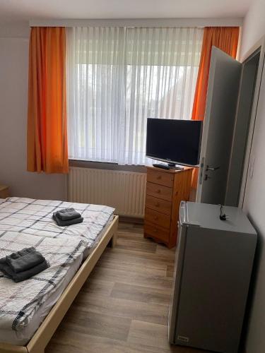 a bedroom with a bed and a flat screen tv at Pension Feist Zimmer 2 in Dagebüll