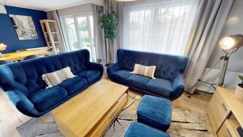 a living room with a blue couch and chairs at Haus Świnoujście in Świnoujście