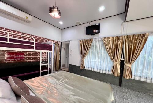 a bedroom with a bed and two windows at MrT Riverside Sampran มิสเตอร์ที โฮมสเตย์-ริมนที in Sam Phran