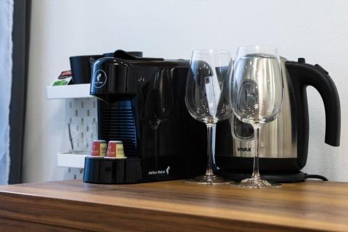 two wine glasses sitting on a counter next to a coffee maker at Palace Luxury Room in Split