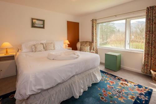 a bedroom with a large bed with a large window at Beckfoot Chapel Stile - Ambleside in Chapel Stile