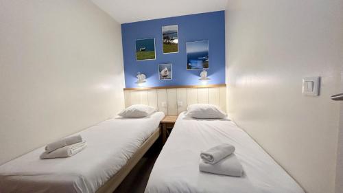 2 camas en una habitación con paredes azules en Argousiers 19 en Fort-Mahon-Plage