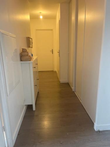 - un couloir avec une porte jaune et du parquet dans l'établissement La Rose, à Drancy