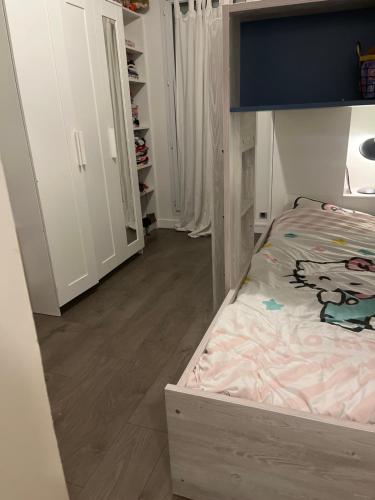 - une petite chambre avec un lit et du parquet dans l'établissement La Rose, à Drancy