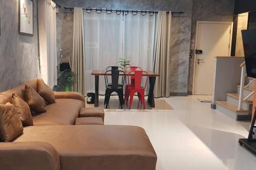 uma sala de estar com um sofá e uma mesa em The Lake Guest House em Ban Bang Phang
