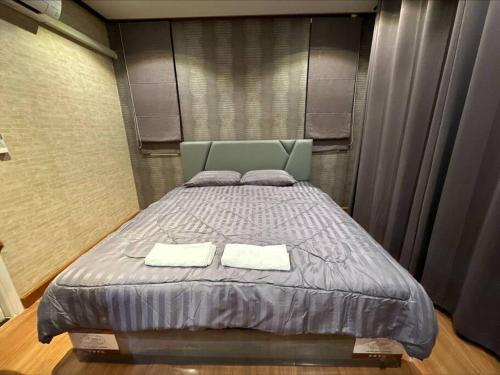 a bedroom with a bed with two towels on it at The Lake Guest House in Ban Bang Phang