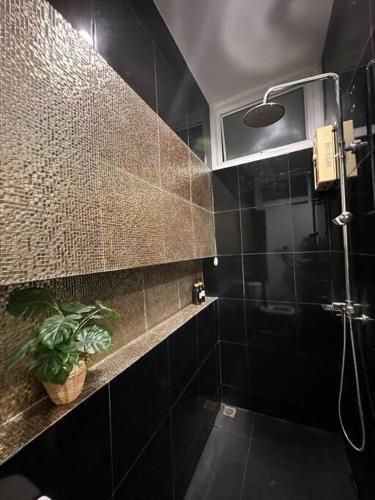 a black bathroom with a shower and a plant at The Lake Guest House in Ban Bang Phang