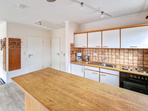 a kitchen with white cabinets and a wooden counter top at Dörte in Greetsiel