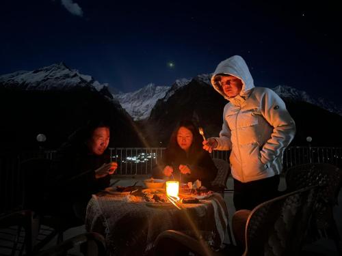 a group of people standing around a table with a candle at Hunza Lounge in Hunza