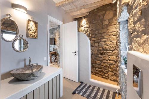 a bathroom with a sink and a stone wall at Your Mykonos in Mýkonos City
