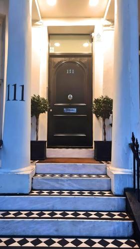 a black front door of a building with stairs at Notting Hill - The One One One!!! -3- in London
