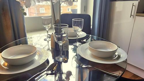 a glass table with plates and wine glasses on it at Notting Hill - The One One One!!! -3- in London
