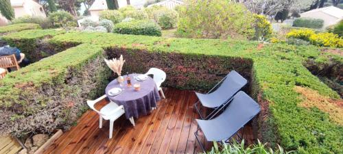 a wooden deck with a table and chairs in a garden at Lovely beach in Sainte-Maxime