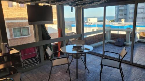 Habitación con vistas a un balcón con mesa y sillas. en APARTAMENTO 1 DORMITORIO EN PUNTA DEL ESTE, en Punta del Este
