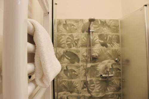 uma cortina de chuveiro na casa de banho com uma toalha em [Fronte lago]ResidenceGarden, moderno appartamento em Calceranica al Lago