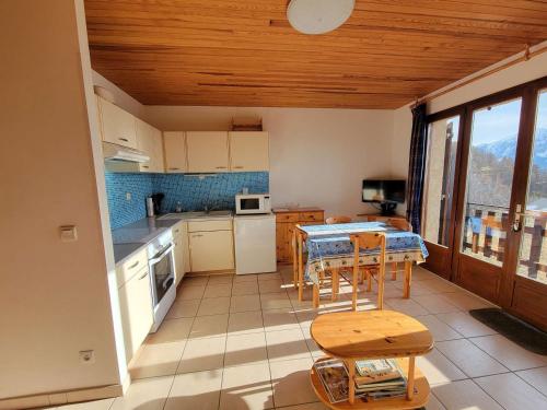 une cuisine avec une table et des chaises dans une pièce dans l'établissement Studio spacieux 4 pers avec balcon à Saint-Michel-de-Chaillol - FR-1-393-8, à Saint-Michel-de-Chaillol
