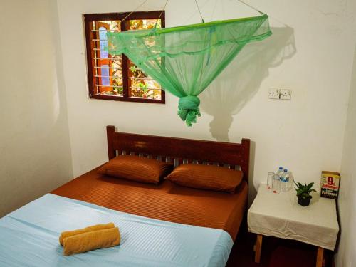 um quarto com uma cama e um guarda-chuva verde em The White House em Trincomalee