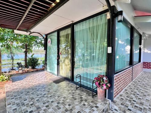 a balcony of a house with a bench and flowers at MrT Riverside Sampran มิสเตอร์ที โฮมสเตย์-ริมนที in Sam Phran