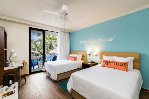 a hotel room with two beds and a balcony at Margaritaville Beach Resort Playa Flamingo in Playa Flamingo