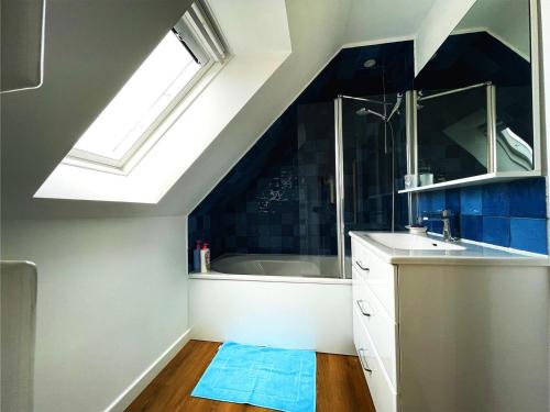 une salle de bain avec un lavabo et une baignoire dans l'établissement Maison Les Agapanthes., à Lanmodez