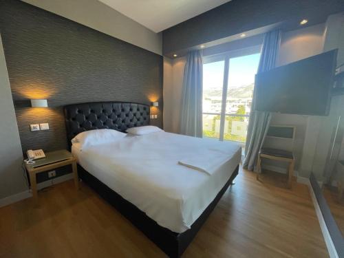 1 dormitorio con cama grande y ventana grande en Kreoli Hotel, en Atenas