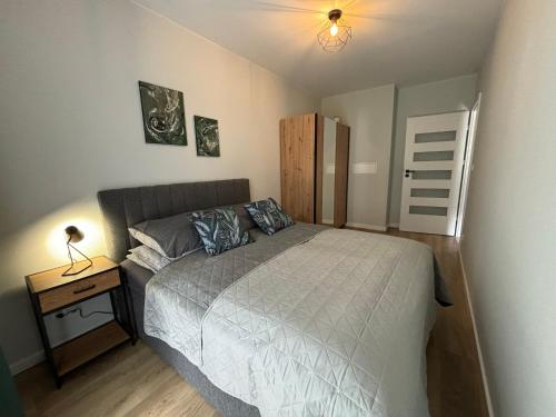 a small bedroom with a bed and a night stand at TOTU TODAY - POSNANIA - MALTA APARTAMENTY , Faktura VAT, self check-in, bezpłatny parking in Poznań