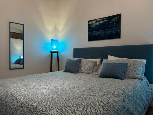 a bedroom with a bed with pillows and a blue lamp at Casa Vacanze Penelope in Trapani